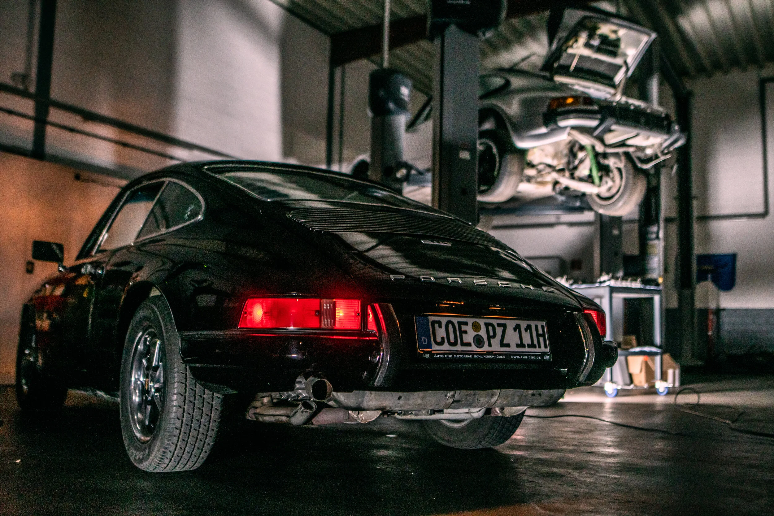 Schwarzer klassischer Porsche 911 von hinten in der Werkstatt